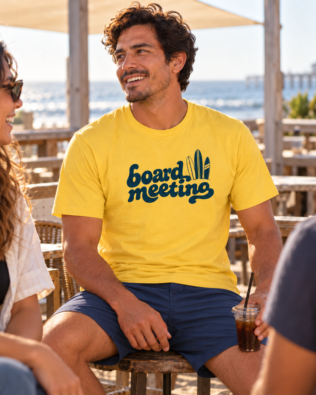 Yellow Board Meeting Tee at a boardwalk cafe with friends
