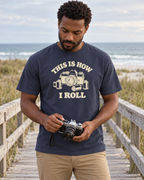 This Is How I Roll Tee — Navy — lifestyle checking a vintage 35mm camera on a coastal boardwalk